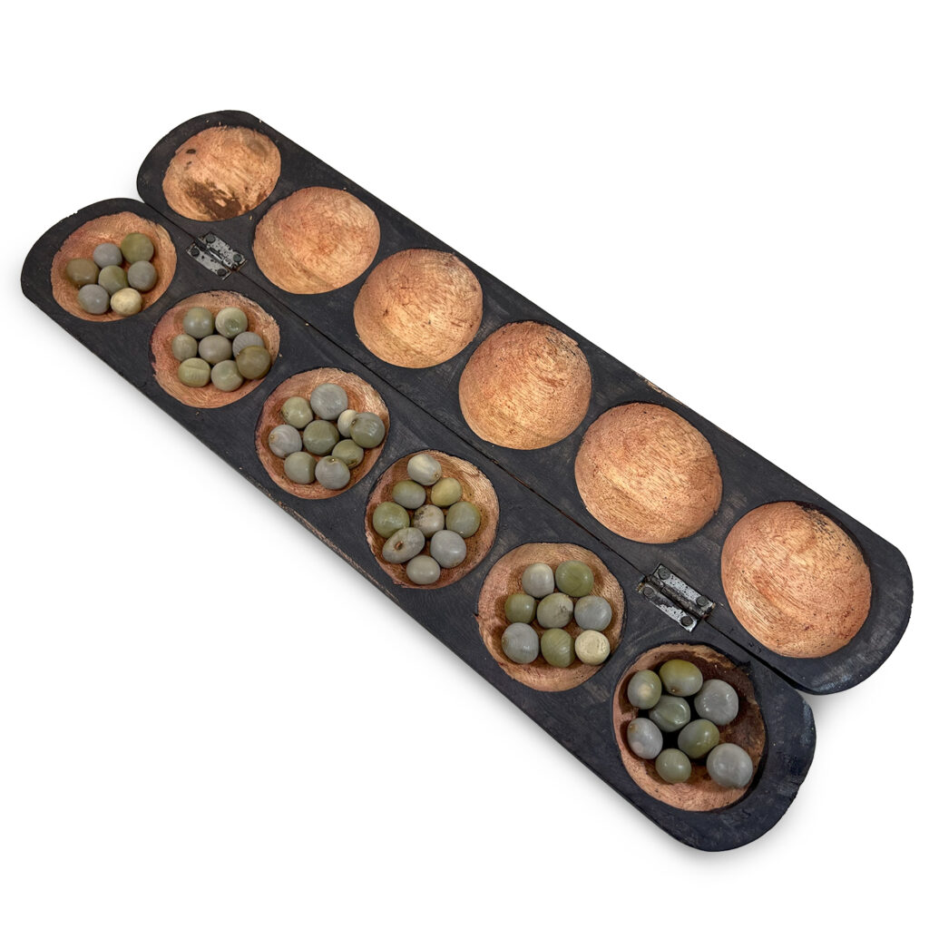 Plateau de mancala traditionnel, rangées de cavités pour jeux de semailles